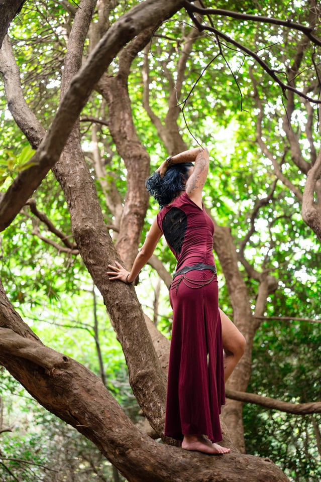 Femme en robe longue dans un arbre, de dos, nature et authentique.